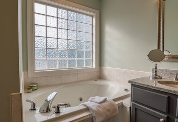 A bathroom with a ceramic tub and quartz counter