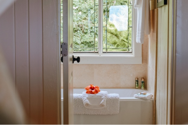 A bathtub with a towel and flower on it