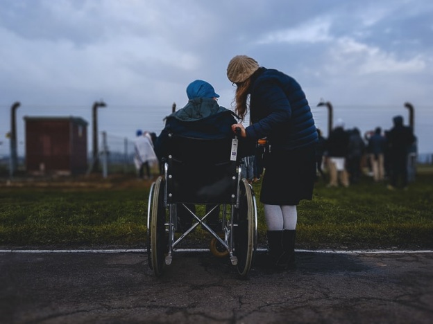 A man in a wheelchair talking to his daughter