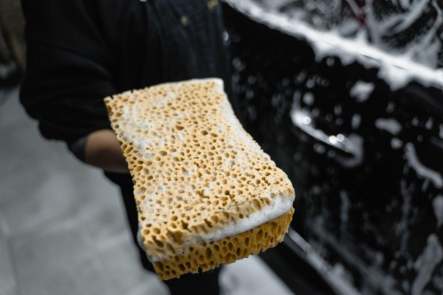 A person holding sponge for cleaning