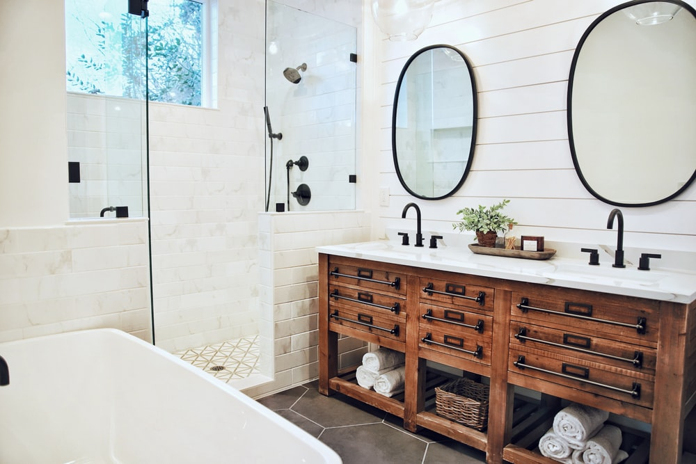 a bathroom with double sink vanity and a tub